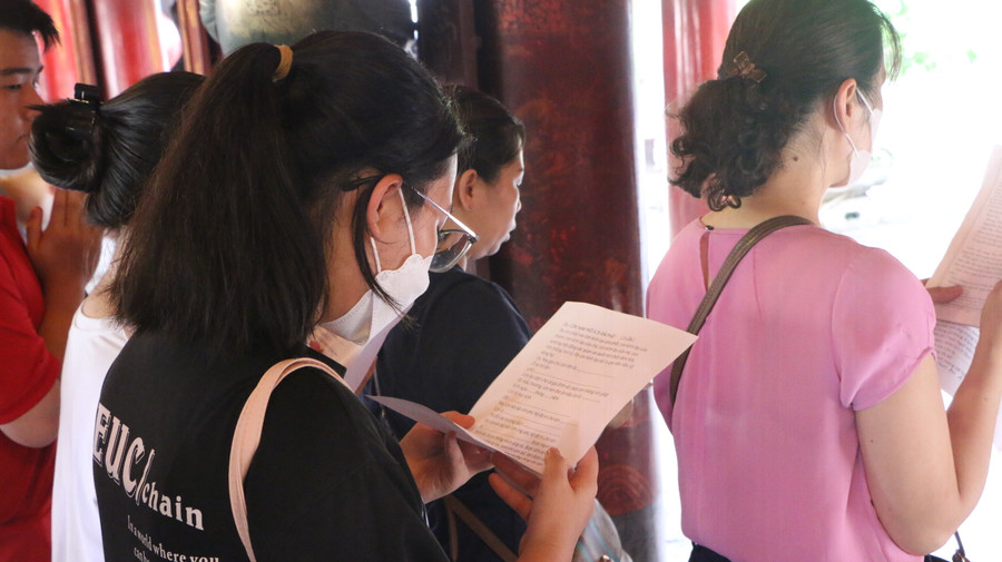 Nhiều bậc phụ huynh còn cẩn thận mang theo cả văn khấn nôm cùng tờ giấy ghi rõ địa chỉ, tên tuổi, trường lớp của con để đọc trước ban thờ tại Văn Miếu.