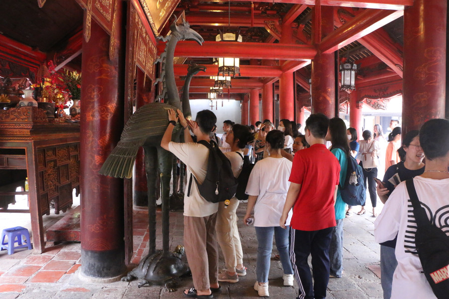 Nhiều thí sinh sau khi làm lễ xong còn tranh thủ xoa tay vào con Hạc bằng đồng với mong muốn cầu bình an, may mắn.