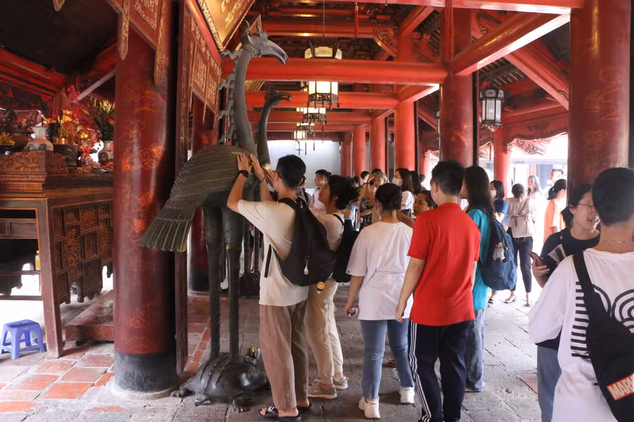 Nhiều thí sinh sau khi làm lễ xong còn tranh thủ xoa tay vào con Hạc bằng đồng với mong muốn cầu bình an, may mắn.