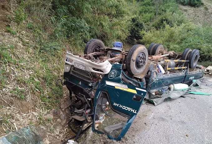 Chiếc xe tải chở hàng tử thiện bị lật ngửa bên đường.