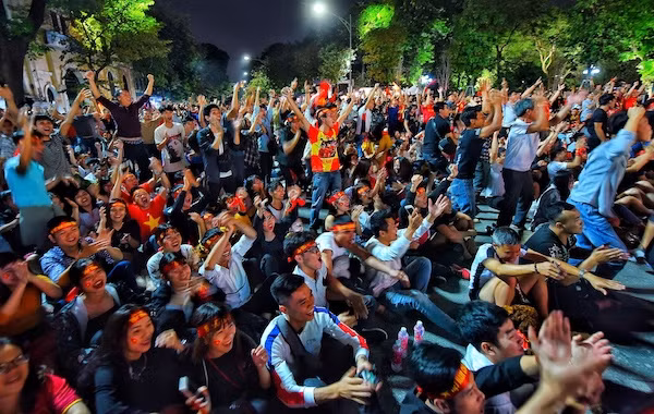 Cổ động viên ăn mừng chiến thắng của tuyển Việt Nam tại phố đi bộ Hồ Gươm. Ảnh: Giang Huy