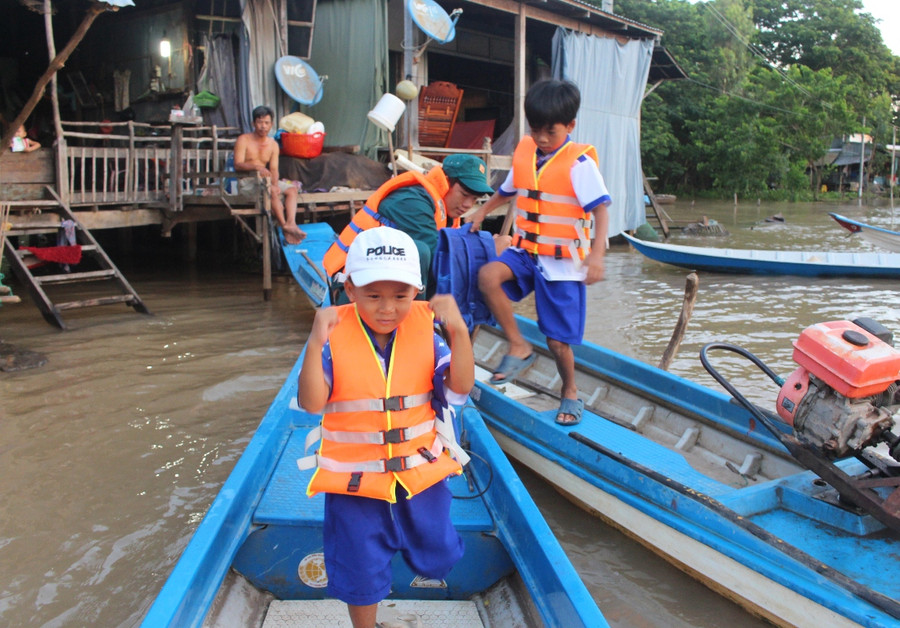 Những em ở khu vực xa trường được lực lượng xã đội tổ chức đưa rước đi học khi nước lũ dâng cao
