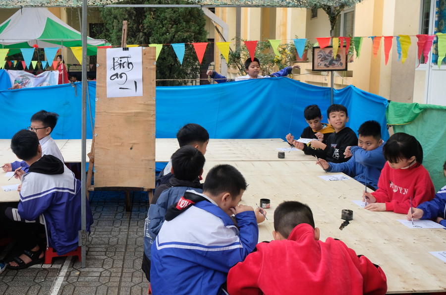 Học sinh trong vai ông Đồ viết thư pháp.