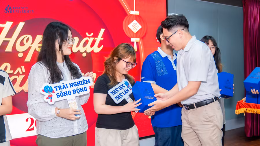 Một giảng viên HSU đang trao quà cho sinh viên.