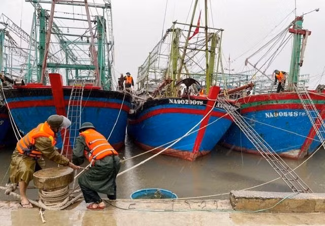 Lực lượng chức năng giúp các chủ tàu cá neo đậu, chằng chống tàu thuyền. 