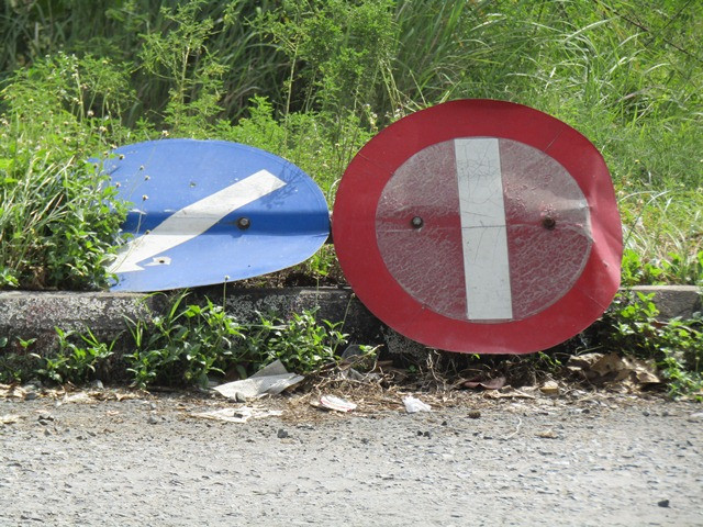 Hai biển báo đổ rạp ven đường đã gần nửa năm nay (ảnh chụp ngày 1/8/2018)