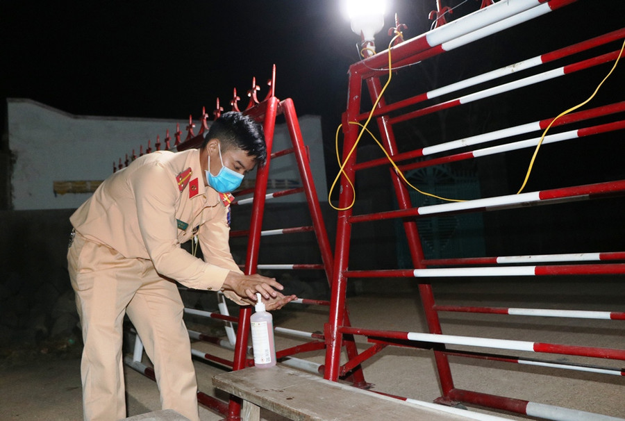 Đến 23h cùng ngày công tác lập chốt cách ly tại thôn Văn Lâm 3 đã hoàn tất. Các chiến sĩ công an rửa tay với cồn sát khuẩn để phòng, chống dịch bệnh Covid - 19. (Ảnh: Ý Thảo).