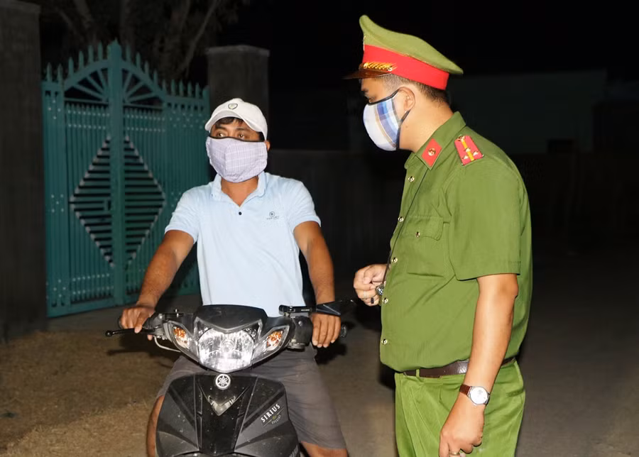 Lực lượng công an tuyên truyền cho người dân hạn chế đi ra ngoiaf khu vực cách ky. (Ảnh: Ý Thảo).