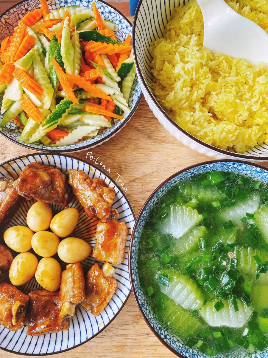 Cơm tám thêm chút bột nghệ nấu cho có màu vàng; Sườn +trứng cút rim chua ngọt; Canh bí xanh; Nộm chua ngọt.