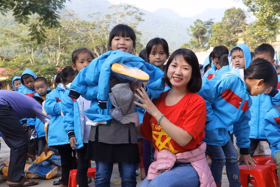 Thành viên trong đoàn từ thiện và học sinh Tiểu học Mường Chanh.