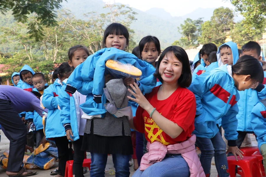 Thành viên trong đoàn từ thiện và học sinh Tiểu học Mường Chanh.