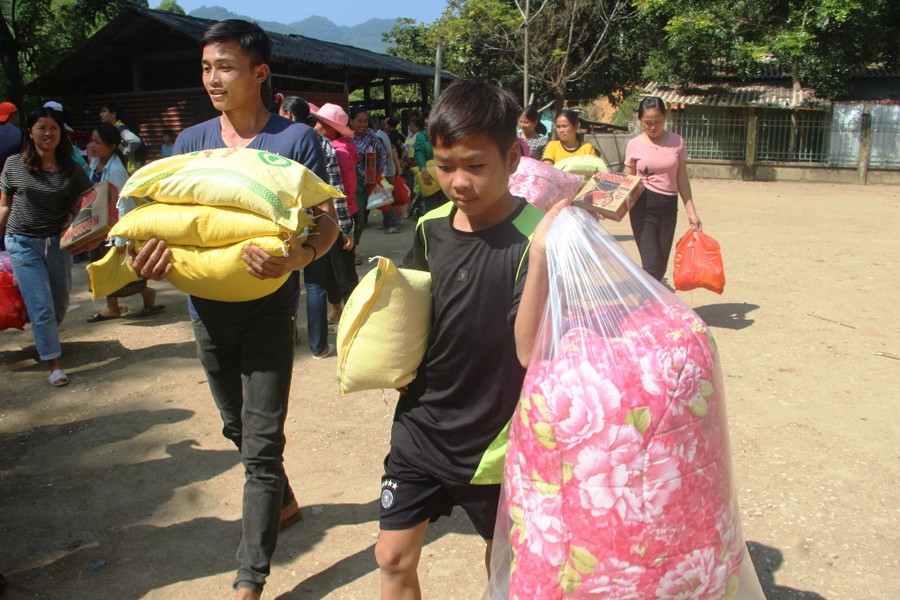 Người dân xã Mường Chanh đón nhận những món quà do đoàn từ thiện trao tặng.