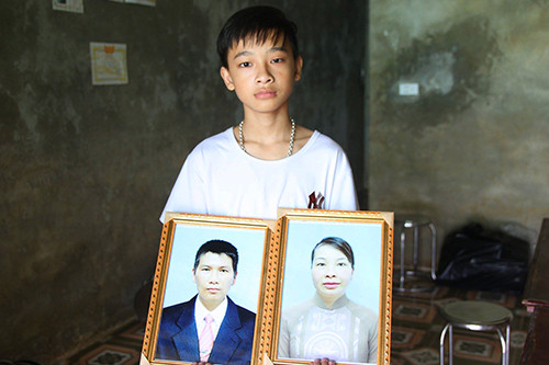 Bé trai đau buồn khi cùng lúc mất cả bố mẹ. Ảnh: Phạm Dự.