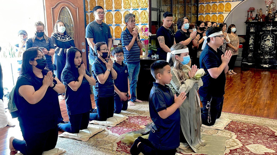 Wendy Phạm cùng ông xã Tom Võ (phải) và con trai Nathan (trái) cầu nguyện cho hương linh Phi Nhung.