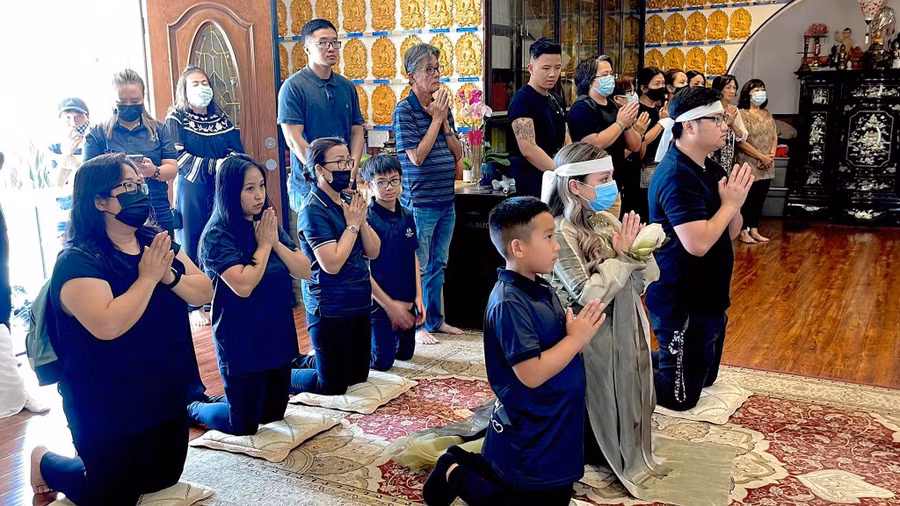 Wendy Phạm cùng ông xã Tom Võ (phải) và con trai Nathan (trái) cầu nguyện cho hương linh Phi Nhung.