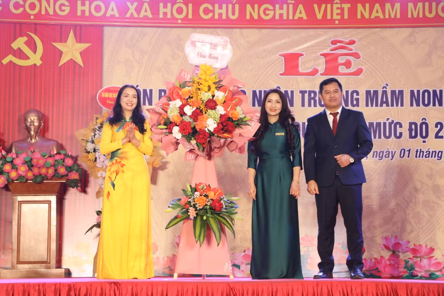 Trưởng Phòng GD&amp;ĐT Đan Phượng Bùi Thị Thu Hằng (trái) tặng hoa chúc mừng nhà trường.