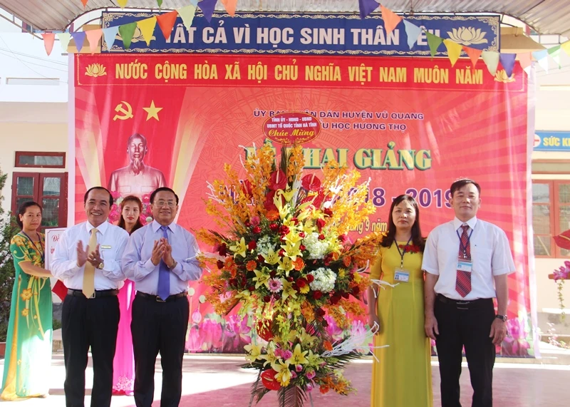 Bí thư Tỉnh ủy Lê Đình Sơn, ông Trần Trung Dũng - Giám đốc Sở GD&ĐT Hà Tĩnh tặng hoa chúc mừng thầy cô giáo, học sinh Trường tiểu học Hương Thọ