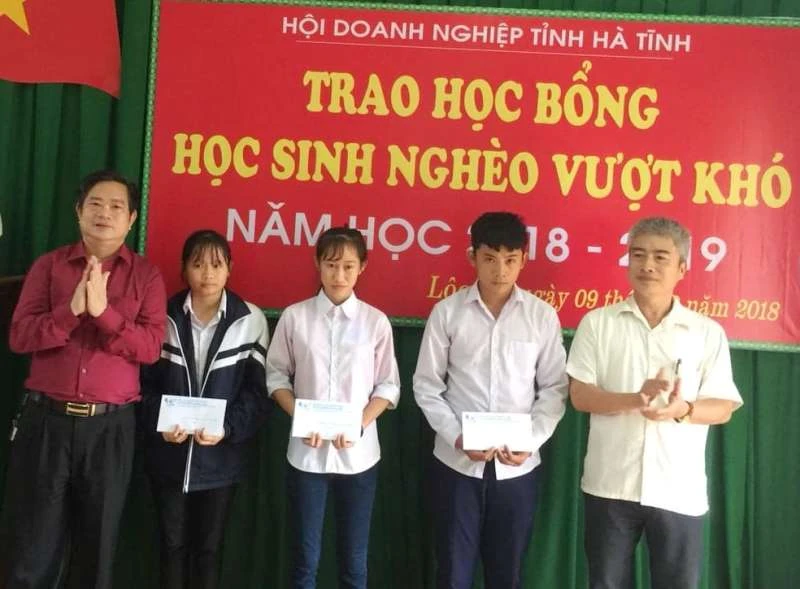 Ông Hoàng Trung Thông (áo đỏ) Chủ tịch Hội doanh nghiệp Hà Tĩnh trao học bổng cho các học sinh nghèo tại huyện Lộc Hà