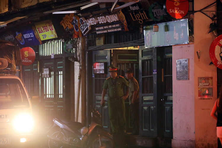 Công an nhắc nhở chủ hộ kinh doanh đóng cửa hàng quán sau 0h. Ảnh: Ngọc Thành