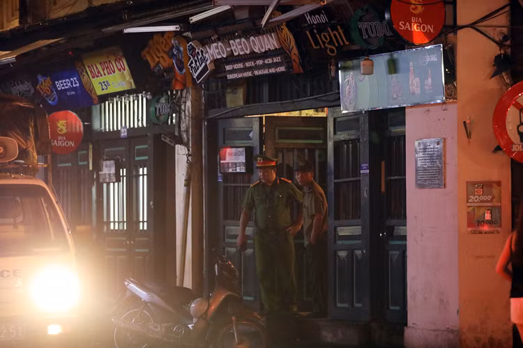Công an nhắc nhở chủ hộ kinh doanh đóng cửa hàng quán sau 0h. Ảnh: Ngọc Thành