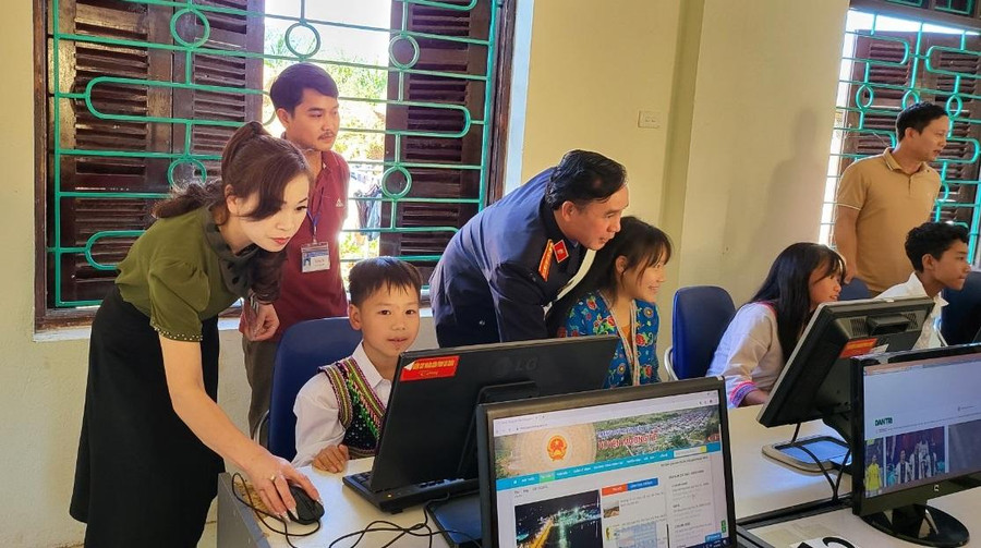 Các đại biểu hướng dẫn học sinh sử dụng máy tính mới.