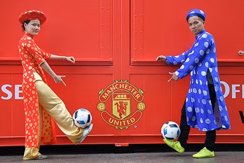 Cặp vợ chồng mặc áo dài tâng bóng tại sân Old Trafford