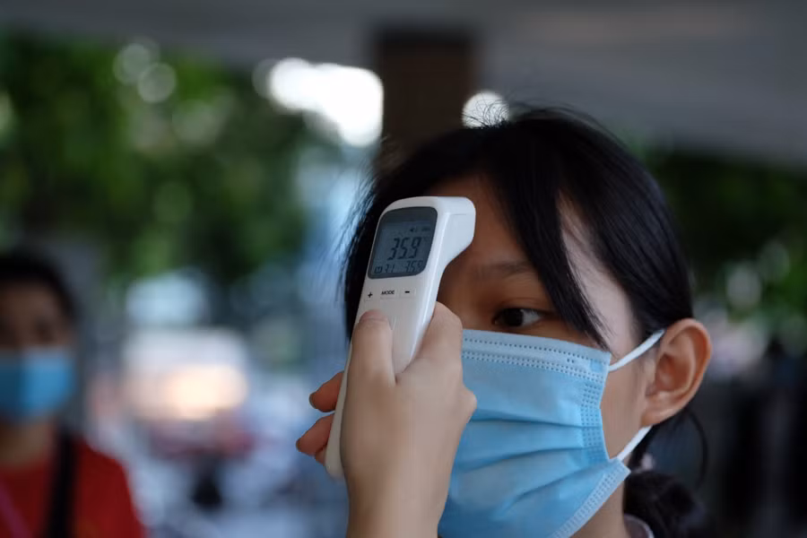 Tại các cổng đi vào trường THPT Phan Châu Trinh đều có cán bộ giáo viên và nhân viên y tế đứng đo thân nhiệt cho học sinh.