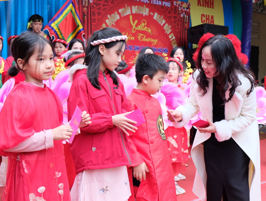 Bà Phạm Thị Như, Phó trưởng Phòng GD&amp;ĐT TP Thanh Hoá trao quà đến 5 học sinh có hoàn cảnh đặc biệt khó khăn của Trường tiểu học Trần Phú. (Ảnh: NT)