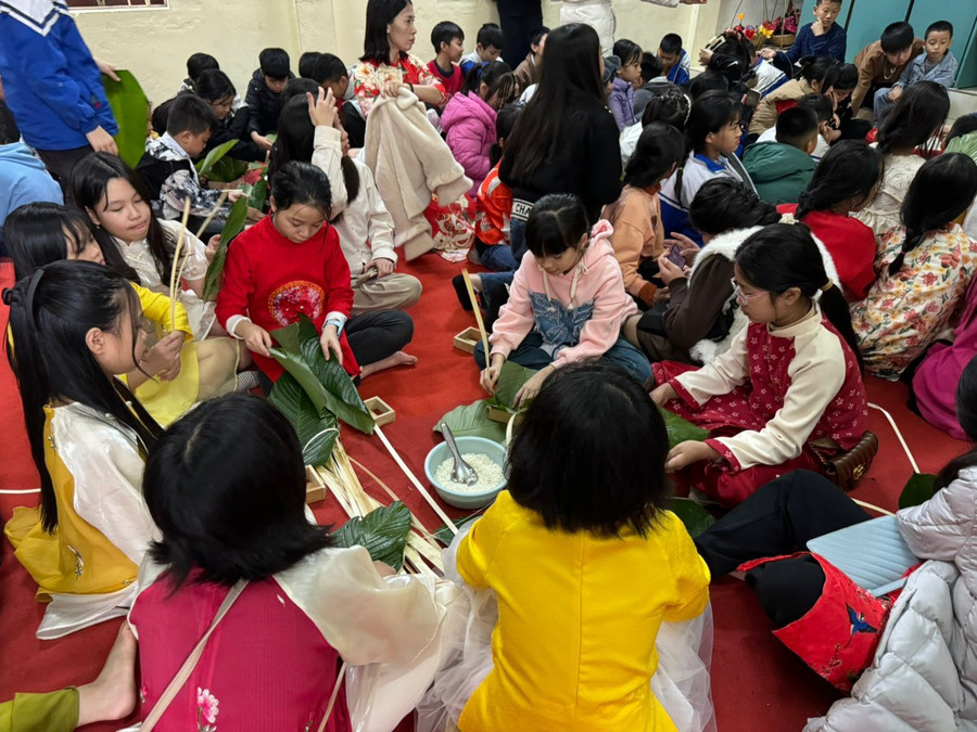 Học sinh được trải nghiệm gói bánh chưng. (Ảnh: NT).