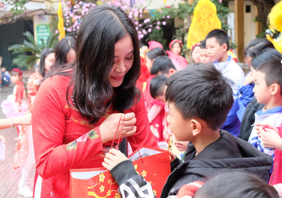 Cô giáo Nguyễn Thị Mai, Hiệu trưởng Trường Tiểu học Trần Phú trao quà tới học sinh nghèo. (Ảnh: NT)