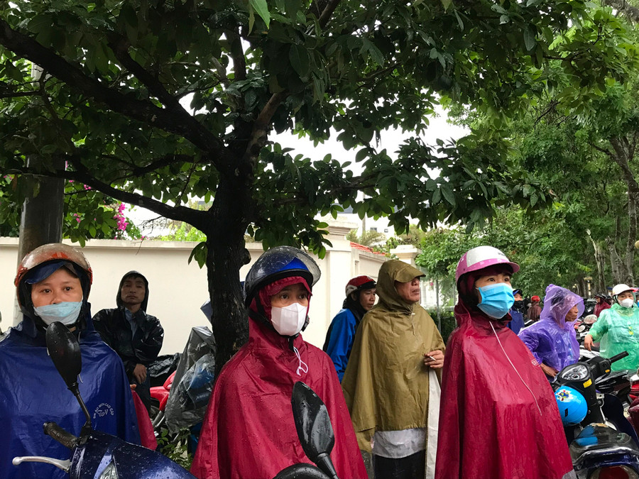 Đội mưa nhìn con vào phòng thi, chị Lê Thị Thảo (đứng giữa) không khỏi hồi hộp, lo lắng: "Con cũng đang căng thẳng nên tôi cũng muốn đứng bên ngoài khu vực thi cổ vũ tinh thần cho con". Đội mưa nhìn con vào phòng thi, chị Lê Thị Thảo (đứng giữa) không khỏi hồi hộp, lo lắng: "Con cũng đang căng thẳng nên tôi cũng muốn đứng bên ngoài khu vực thi cổ vũ tinh thần cho con".