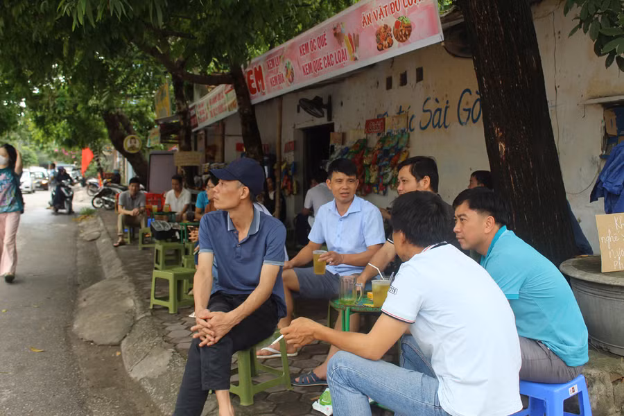 Phụ huynh học sinh ngồi ngoài quán nước đợi sĩ tử vào thi môn tiếng Anh tại Hội đồng thi Trường THPT Hàm Rồng. Ảnh: LT.