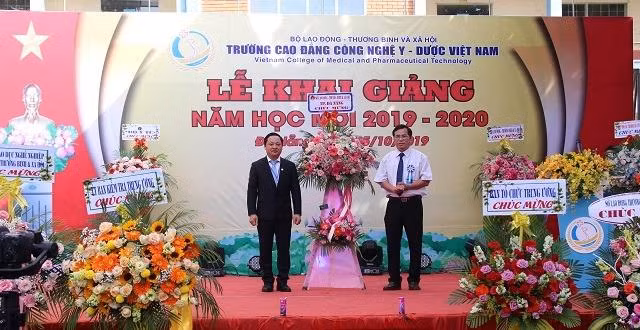 Đại diện nhà trường nhận hoa chúc mừng trong buổi khai giảng. 