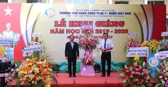 Đại diện nhà trường nhận hoa chúc mừng trong buổi khai giảng. 