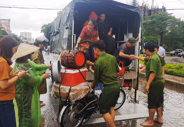 Mưa lớn kéo dài, nhiều tuyến đường ngập sâu trong nước khiến phương tiện giao thông ngập nước, chết máy. Đội Cảnh sát trật tự Công an TP Vinh (Nghệ An) đã sử dụng xe chuyên dụng giúp người dân qua vùng ngập nước. (Ảnh: Hoàng Lam)