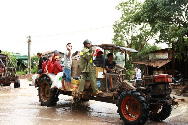 Người dân phải dùng xe máy cày vận chuyển vật dụng, hàng hóa di chuyển qua vùng ngập lụt.