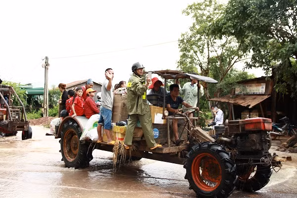 Người dân phải dùng xe máy cày vận chuyển vật dụng, hàng hóa di chuyển qua vùng ngập lụt.