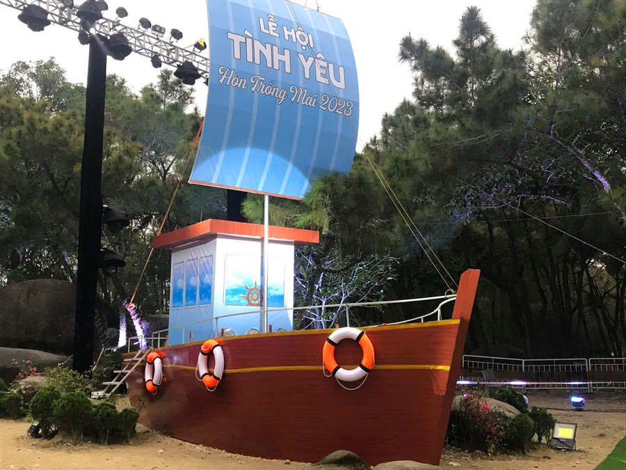 Chiếc thuyền mang dòng chữ: "Lễ hội tình yêu hòn Trống Mái 2023" trên sâu khấu. Ảnh: LT. Chiếc thuyền mang dòng chữ: "Lễ hội tình yêu hòn Trống Mái 2023" trên sâu khấu. Ảnh: LT.