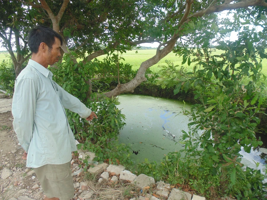 Ông Nguyễn Đăng Thuận chỉ cho chúng tôi giếng nước được tạo từ hố bom, nguồn nước chính của thôn trước đây.