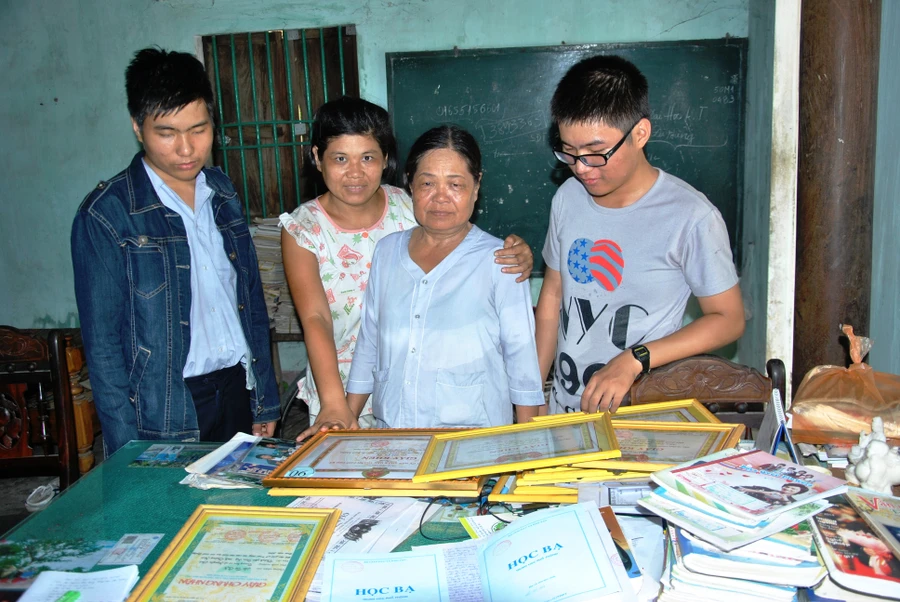 Hồ Tú Ân (bên trái), Hồ Tú Ẩn (bên phải) cùng mẹ và chị gái vui mừng trước thành tích học tập của 2 em.