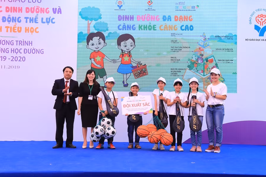 Tiến sĩ Tạ Ngọc Trí, Phó Vụ trưởng Vụ Giáo dục Tiểu học trao phần thưởng cho đội giành giải xuất sắc của buổi giao lưu "Tìm hiểu kiến thức dinh dưỡng"