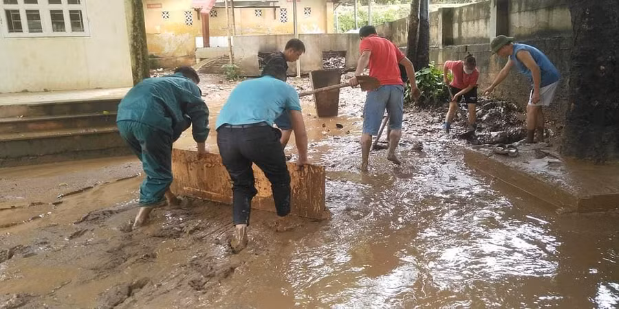 Cán bộ xã Tà Hộc hỗ trợ dọn vệ sinh sau mưa lũ.