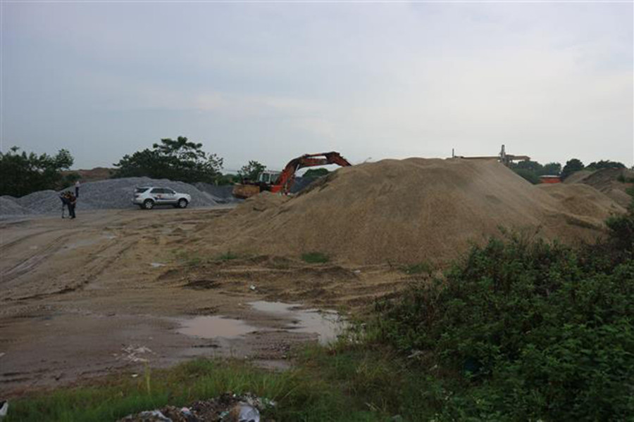 Một bãi trung chuyển, tập kết vật liệu không phép trên đê