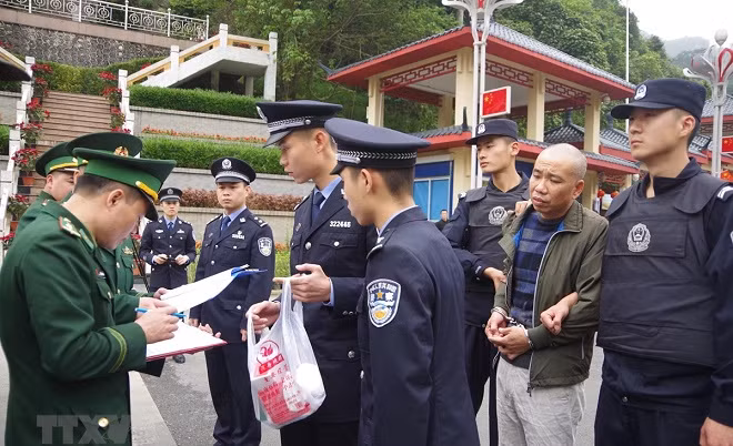 Tăng cường hợp tác giữa Bộ Công an Việt Nam và Trung Quốc Lực lượng chức năng Việt Nam tiếp nhận đối tượng bị truy nã Trịnh Đức Thọ do phía Công an Trung Quốc trao trả ngày 26/3. (Ảnh: Ngọc Tùng/TTXVN) 