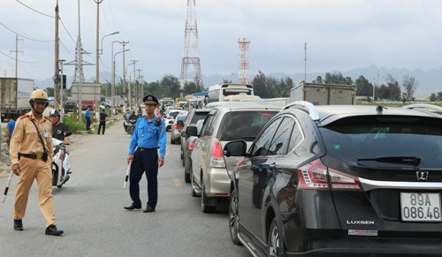Các phương tiện xếp hàng chờ phà, kéo dài khoảng 2km từ đầu phà ra đến gần khu tổ hợp nhà máy ô tô Vinfast. Ảnh: Giang Chinh