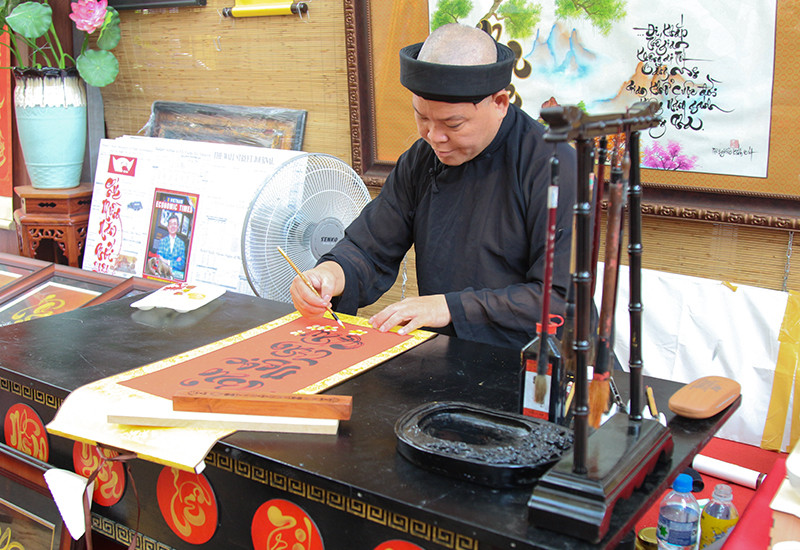 Ông đồ viết những câu chúc mừng xuân Canh Tý dành tặng cho khách tham quan
