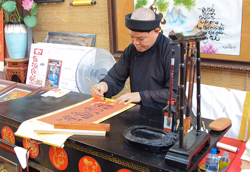 Ông đồ viết những câu chúc mừng xuân Canh Tý dành tặng cho khách tham quan