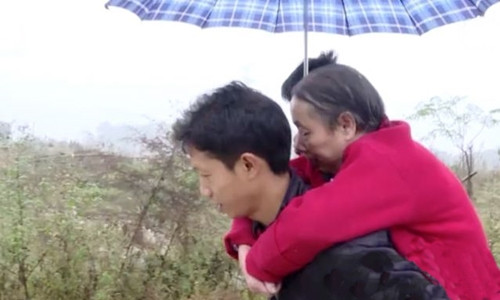 Wang Xianqiang cõng mẹ đi dạo. Ảnh:Weibo. Wang Xianqiang cõng mẹ đi dạo. Ảnh: Weibo.