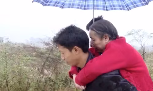 Wang Xianqiang cõng mẹ đi dạo. Ảnh: Weibo.
