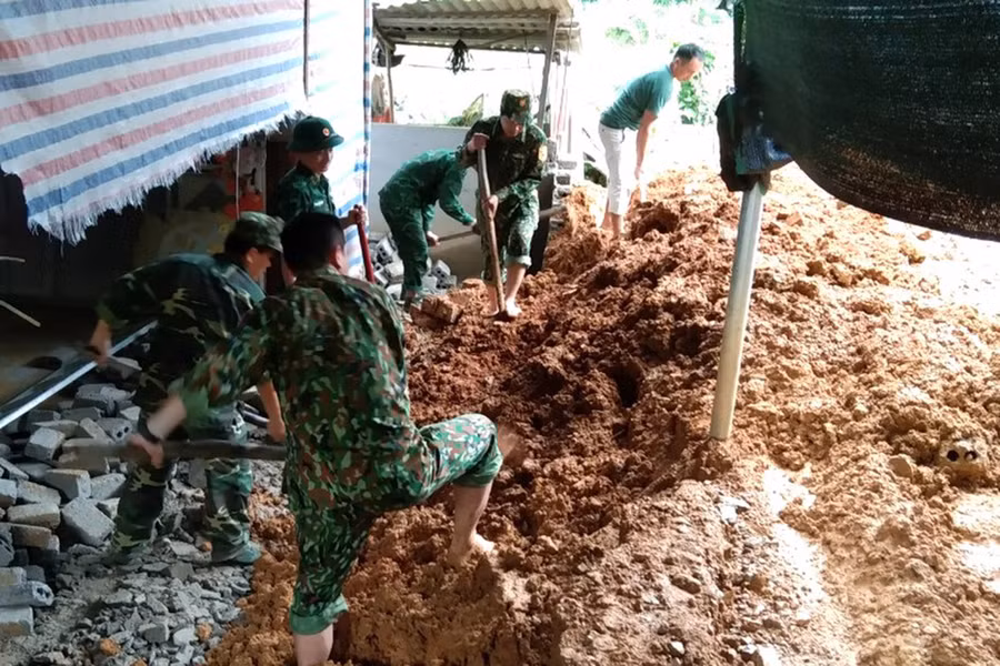 Cán bộ, chiến sĩ Đồn Biên phòng Thông Thụ giúp người dân khắc phục hậu quả mưa lũ.